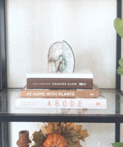 crystal book ends on top of white notebook and books on mindful living